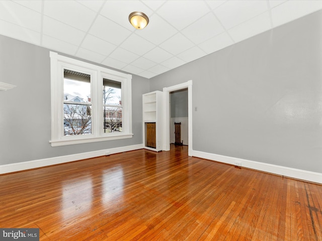 unfurnished room featuring a paneled ceiling and hardwood / wood-style flooring