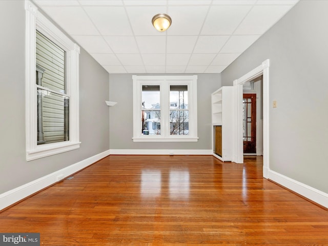 unfurnished room featuring a drop ceiling and hardwood / wood-style flooring