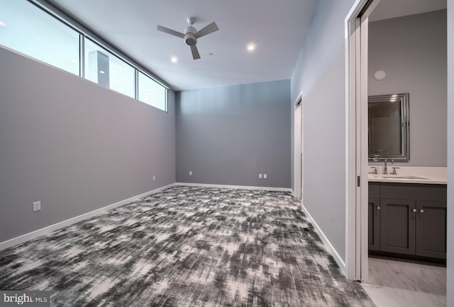 spare room featuring sink, a high ceiling, and ceiling fan