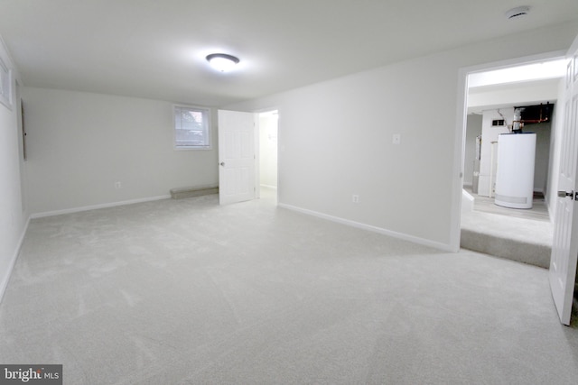 unfurnished room featuring light carpet and water heater