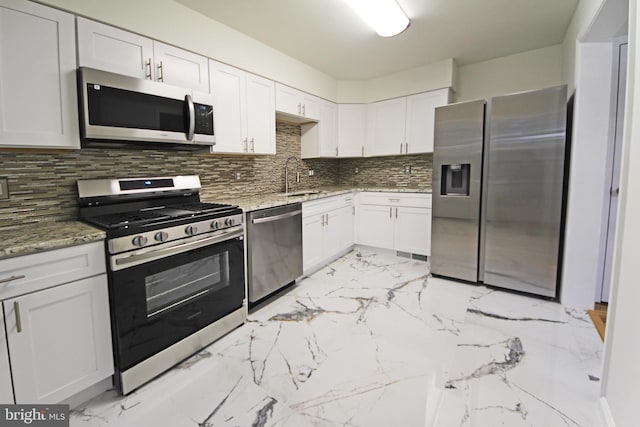 kitchen featuring appliances with stainless steel finishes, backsplash, stone countertops, and white cabinetry