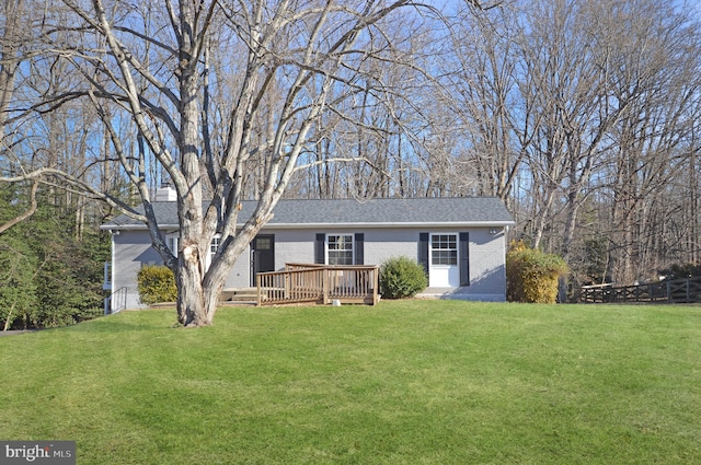 ranch-style house featuring a front yard and a wooden deck