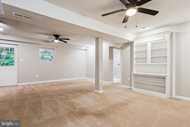 unfurnished living room with light carpet, ceiling fan, and a textured ceiling