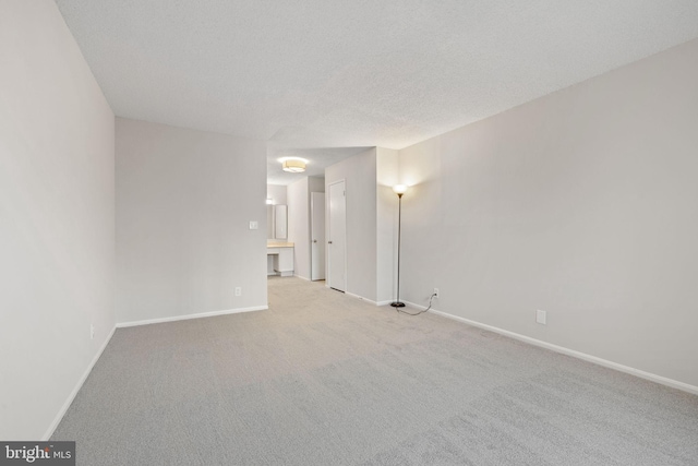 empty room featuring light carpet and a textured ceiling