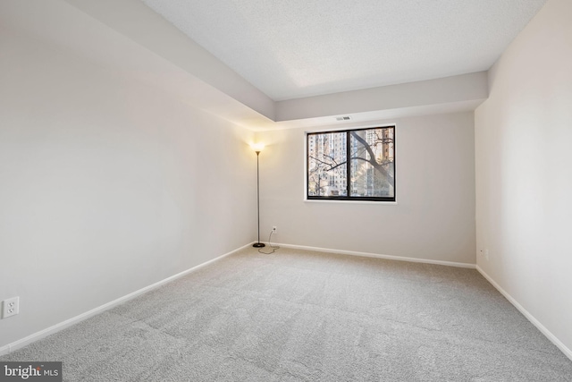 carpeted spare room featuring a textured ceiling