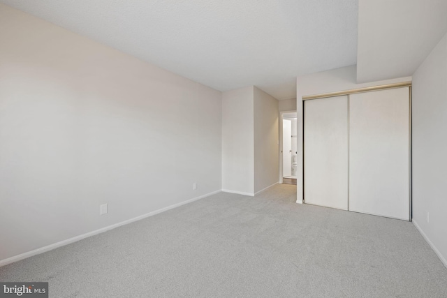 unfurnished bedroom with a closet and light carpet