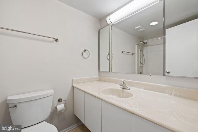 bathroom featuring walk in shower, vanity, and toilet