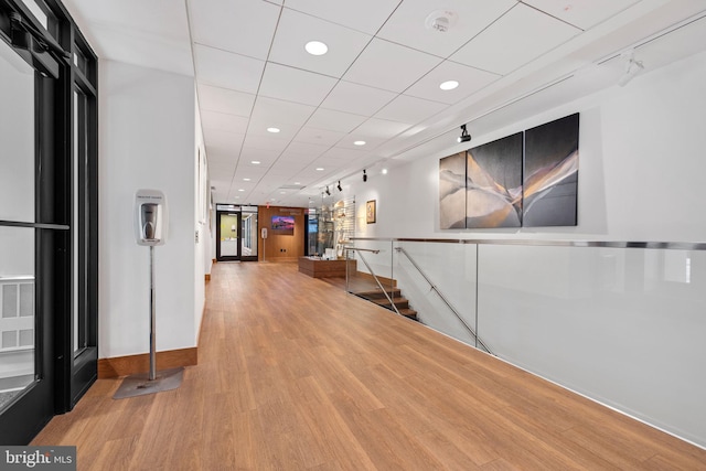 hall with track lighting and light hardwood / wood-style floors