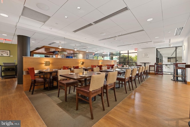 dining room featuring a paneled ceiling and light hardwood / wood-style flooring