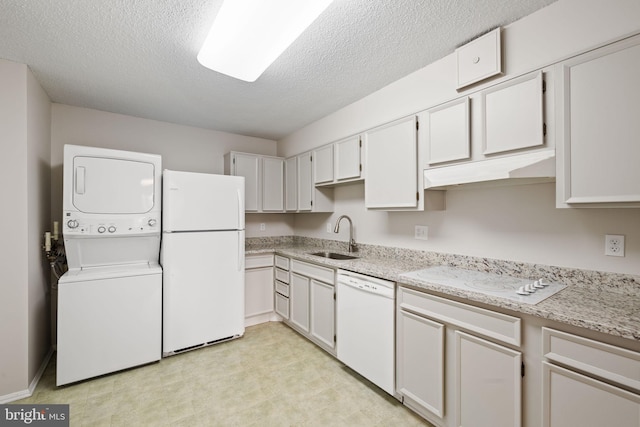 kitchen with stacked washer / drying machine, sink, white cabinetry, a textured ceiling, and white appliances