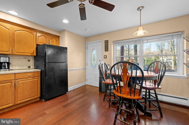 kitchen featuring pendant lighting, plenty of natural light, black fridge, and tasteful backsplash