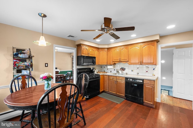 kitchen featuring decorative backsplash, sink, dark hardwood / wood-style floors, and black appliances