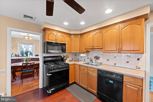 kitchen featuring ceiling fan, sink, dark hardwood / wood-style flooring, backsplash, and black appliances