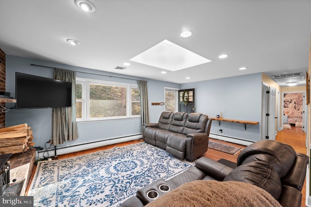 living room with a skylight, a baseboard radiator, and light hardwood / wood-style floors