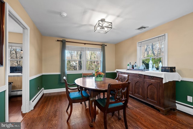 dining area featuring baseboard heating and dark wood-type flooring