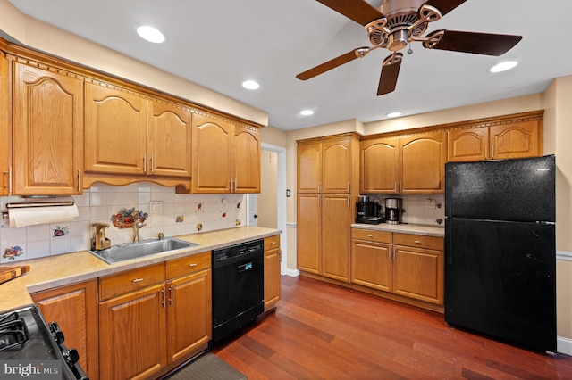 kitchen with sink, dark hardwood / wood-style flooring, tasteful backsplash, and black appliances