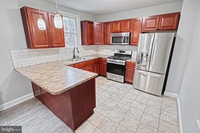 kitchen with sink, backsplash, kitchen peninsula, pendant lighting, and appliances with stainless steel finishes