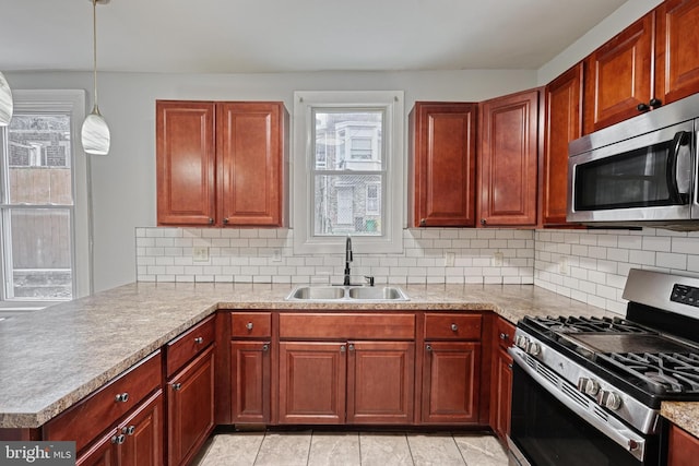 kitchen with sink, hanging light fixtures, tasteful backsplash, kitchen peninsula, and stainless steel appliances