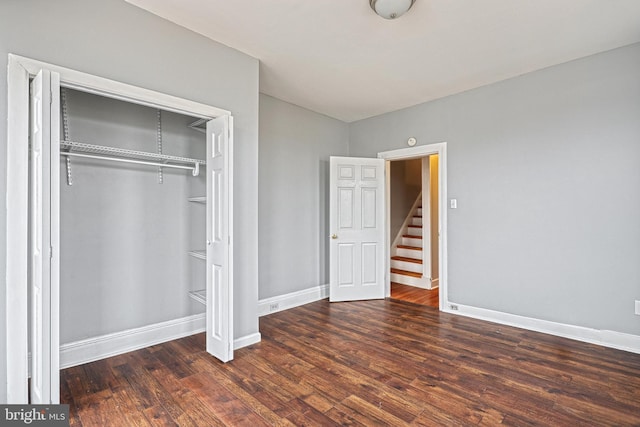 unfurnished bedroom featuring dark hardwood / wood-style flooring and a closet