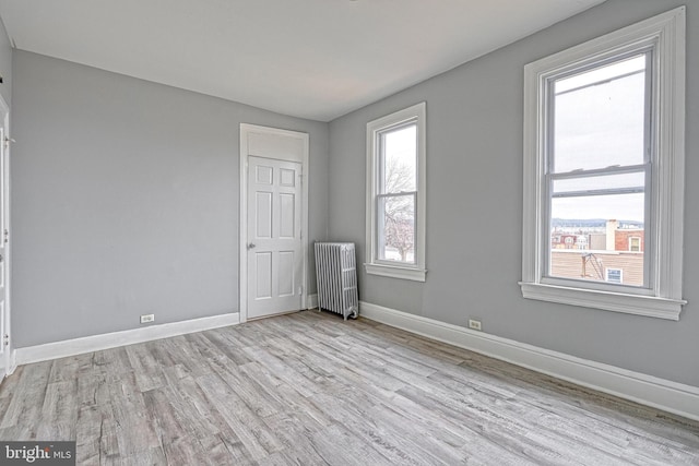 unfurnished bedroom featuring light wood-type flooring and radiator