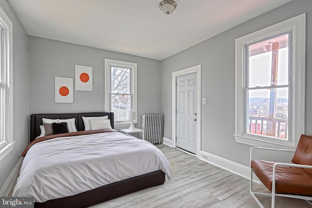 bedroom featuring radiator and light hardwood / wood-style flooring