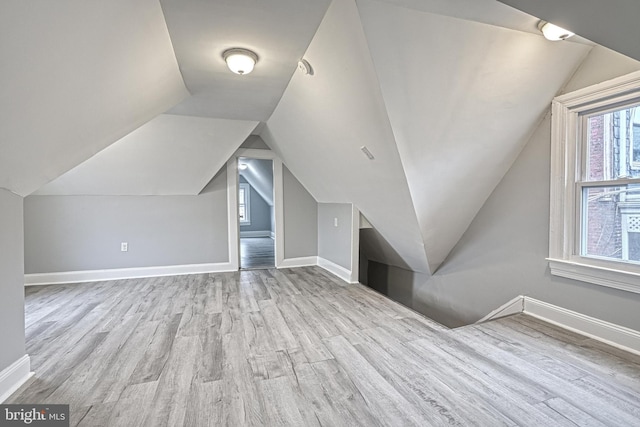 additional living space featuring light hardwood / wood-style flooring and lofted ceiling