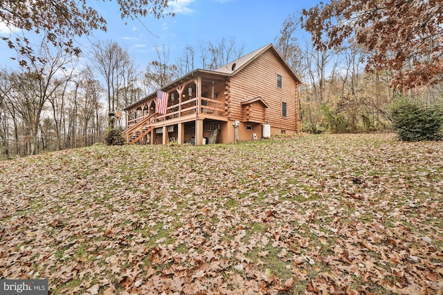 rear view of property featuring a wooden deck and a sunroom