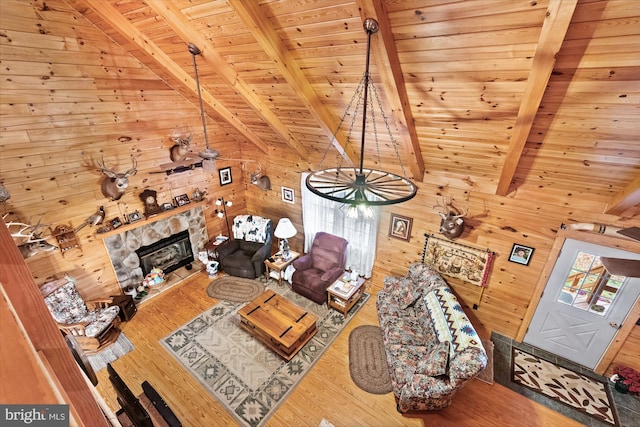 unfurnished living room featuring wood-type flooring, vaulted ceiling with beams, wooden walls, and wood ceiling