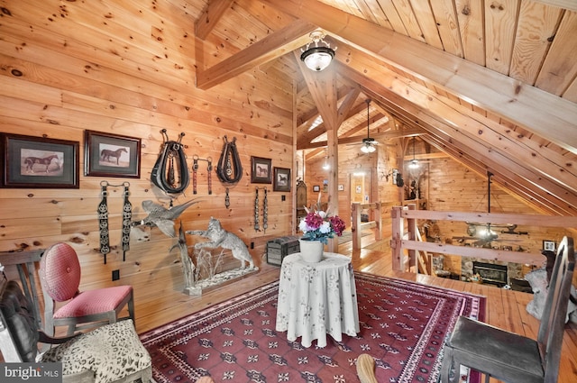 interior space featuring lofted ceiling with beams, wooden walls, and wood ceiling