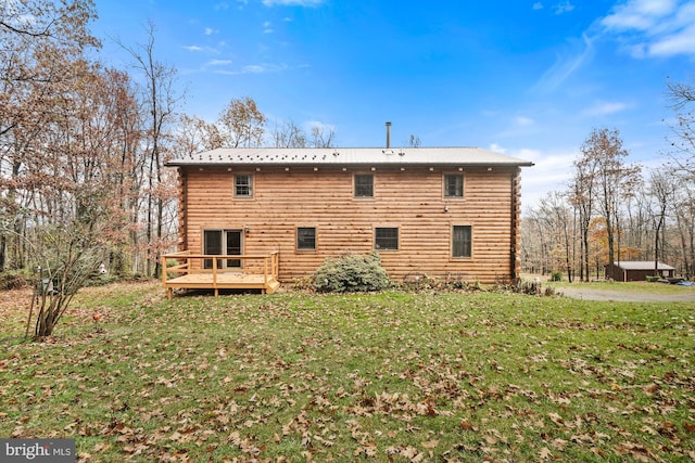 rear view of house with a wooden deck and a yard