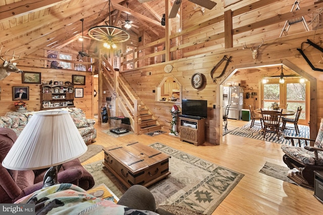 living room featuring beamed ceiling, wooden ceiling, and wood walls