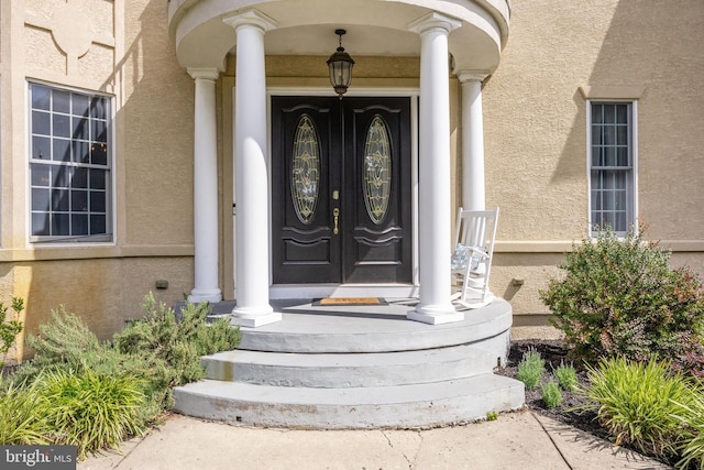 view of exterior entry with a porch