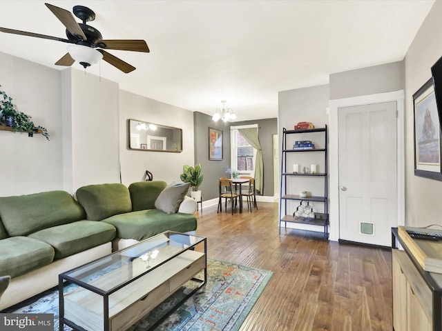 living room featuring dark hardwood / wood-style flooring and ceiling fan with notable chandelier