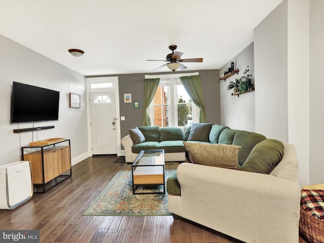 living room with ceiling fan and dark wood-type flooring