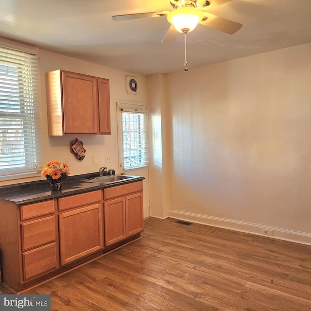 kitchen featuring dark hardwood / wood-style floors, ceiling fan, and sink