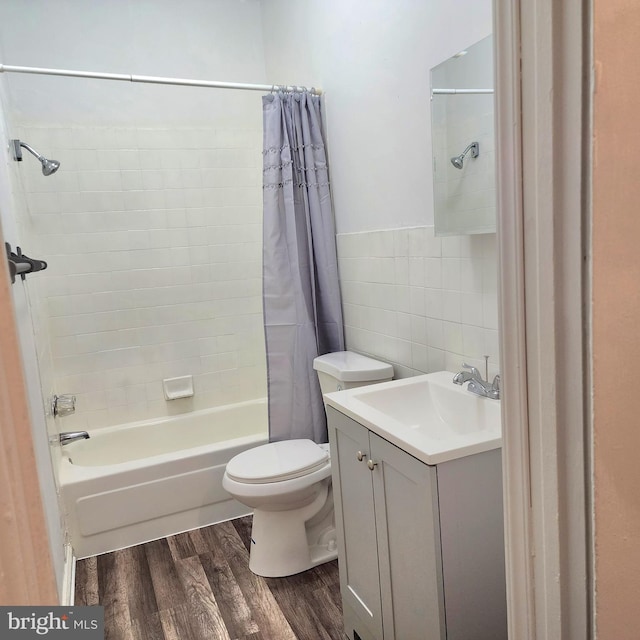 full bathroom featuring shower / bath combination with curtain, toilet, vanity, tile walls, and hardwood / wood-style flooring