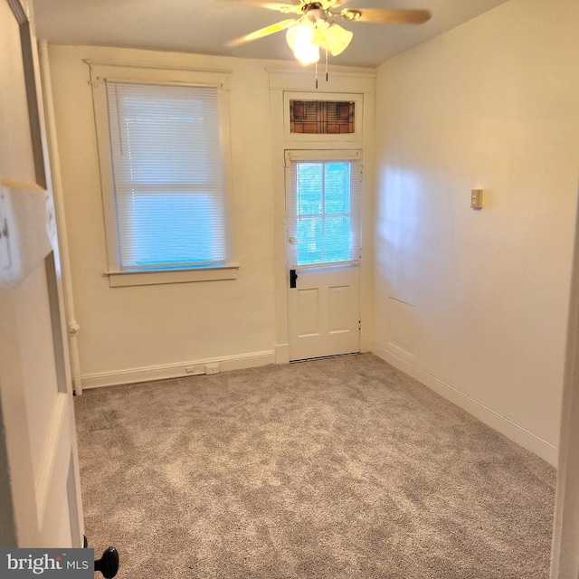 doorway featuring light carpet and ceiling fan