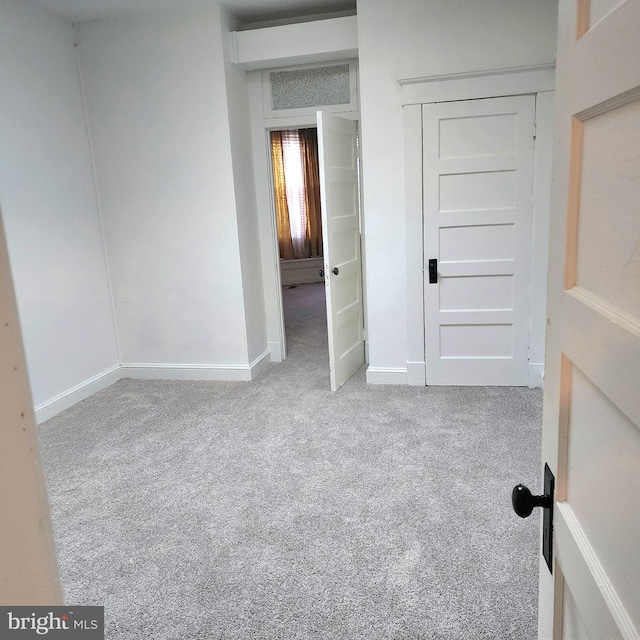 unfurnished bedroom featuring light carpet and a closet