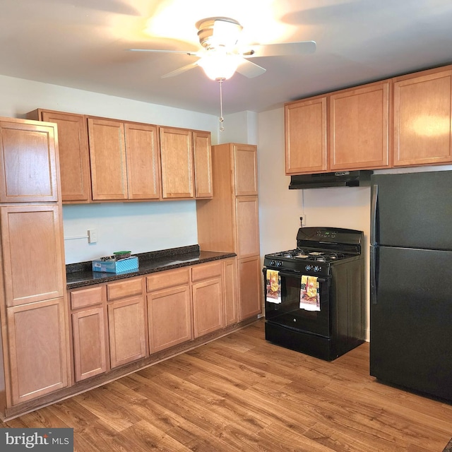 kitchen featuring black appliances, ceiling fan, dark stone countertops, and light hardwood / wood-style flooring