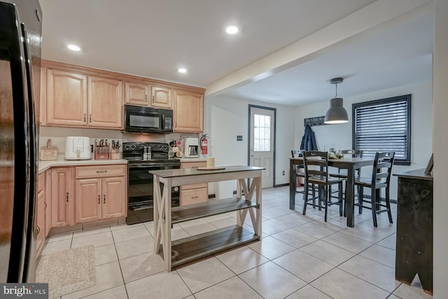 kitchen featuring light tile patterned floors, hanging light fixtures, light brown cabinetry, and black appliances