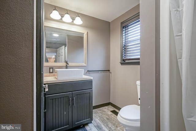 bathroom with hardwood / wood-style floors, vanity, and toilet