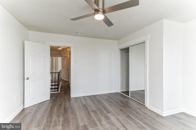 unfurnished bedroom featuring light hardwood / wood-style floors, a closet, and ceiling fan