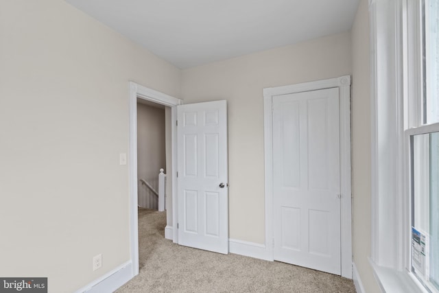 unfurnished bedroom featuring light carpet