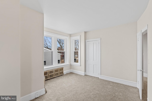 carpeted spare room with radiator heating unit