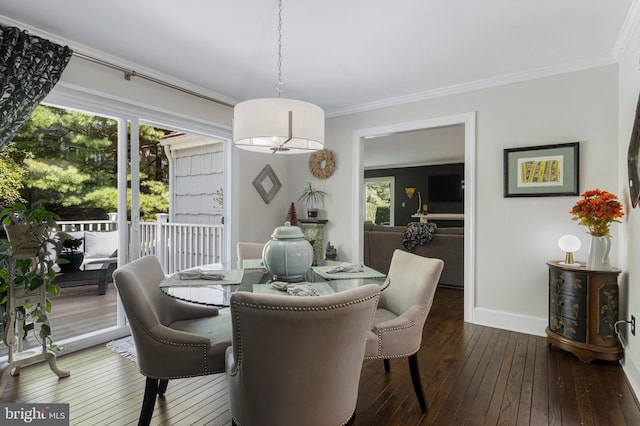 dining space with dark hardwood / wood-style flooring and crown molding