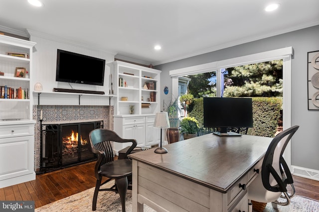 office space with a tiled fireplace, dark hardwood / wood-style flooring, and ornamental molding