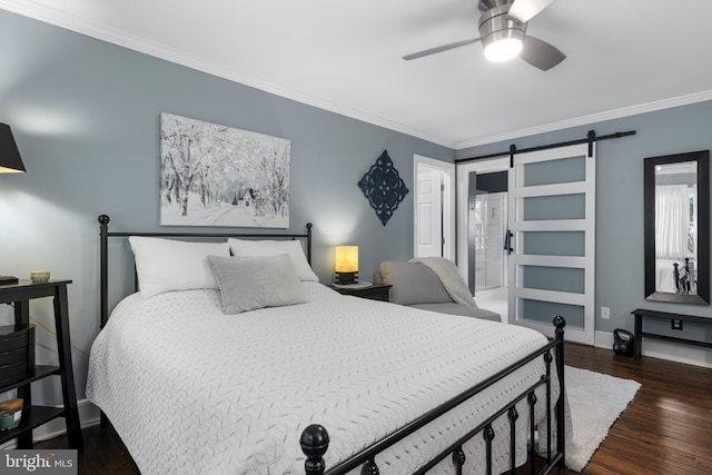 bedroom featuring dark hardwood / wood-style flooring, ensuite bath, ceiling fan, crown molding, and a barn door