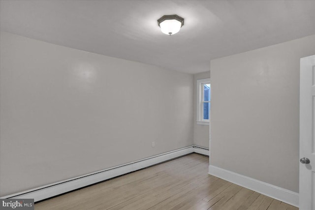 spare room featuring light wood-type flooring and baseboard heating