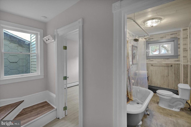 bathroom with toilet, shower / bathtub combination with curtain, and a baseboard heating unit