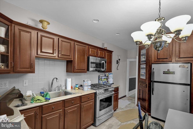 kitchen featuring sink, decorative light fixtures, decorative backsplash, a notable chandelier, and stainless steel appliances